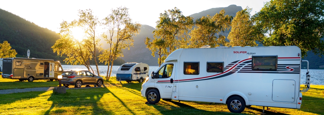 An RV camper parked in a campsite near the lake